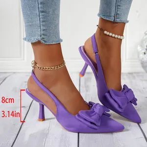 Nahaufnahme lila spitz zulaufende High Heels mit Schleife und 8 cm Pfennigabsatz