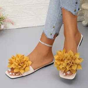 Detailed view of women's flat sandals featuring vibrant yellow floral decorations