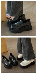 Close-up detail view of women's retro platform loafers in black and off-white colors