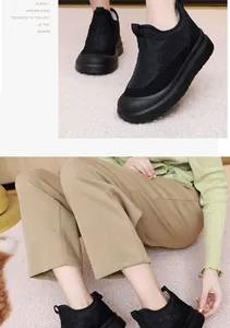 Primer plano de botas de nieve de invierno negras con textura acolchada y suela gruesa