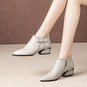 Elegant ivory Chelsea boots for women with bow detail and block heel in crocodile leather.