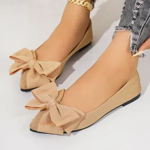 Close-up detail of sparkling champagne flat shoes with an elegant oversized bow