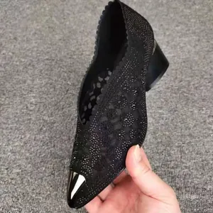 Gedetailleerde weergave van zwarte mesh holle schoenen met strass en spitse neus.