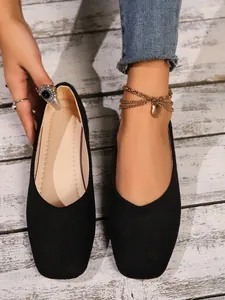 Close-up view of elegant black suede flat shoes for women with a comfortable slip-on design