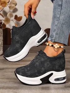 Detail von schwarzen Denim-Wedge-Sneakern mit Frontreißverschluss und Plateausohle.