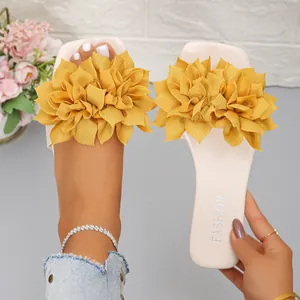 Detailed view of women's flat sandals featuring large yellow fabric flowers and square toe