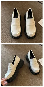 Close-up view of white retro platform loafers with thick black soles and JK style design