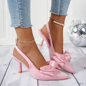 Detailaufnahme von rosa Satin-Slingback-Heels mit eleganter Schleife und spitzer Zehenpartie