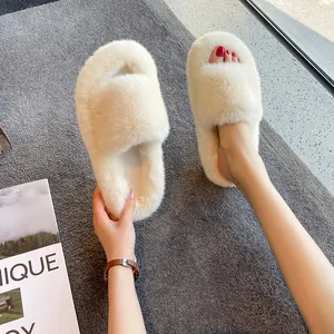 Close-up of plush faux fur slippers featuring a thick platform sole and soft cream texture