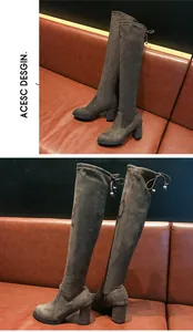 Détail rapproché montrant la texture et le design des bottes cuissardes grises à talons hauts