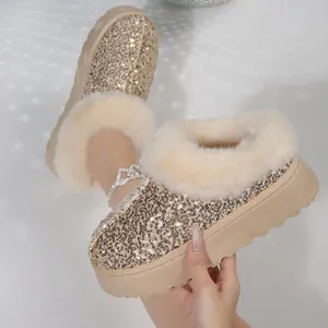 Primer plano de botas de nieve doradas con lentejuelas, plataforma y pelo sintético suave