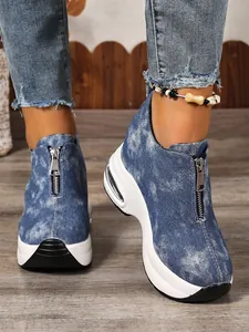 Detailansicht der blauen Denim-Plateau-Sneaker mit Frontreißverschluss und Keilabsatz.