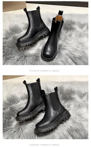 Detailed look at black thick sole Chelsea boots for women on a grey faux fur rug