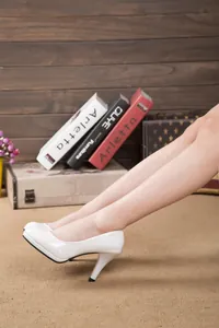 Detailed side view of white patent leather round toe platform pumps with elegant stiletto heels