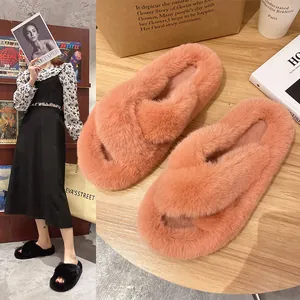 Soft coral faux fur cross band slippers displayed on a rustic wooden table setting