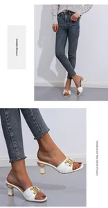 Detailansicht weißer High-Heel-Pantoletten mit eleganter goldener Metallkette für Damen