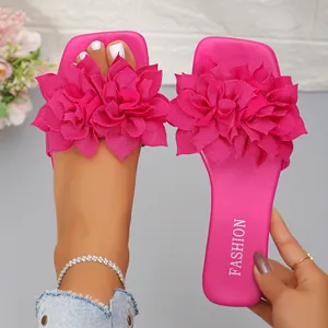 Detail of fuchsia flat sandals with elegant double fabric flower decorations and square toe.