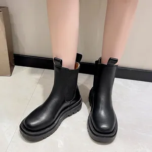 Detailed on-feet view of black platform Chelsea boots featuring mid-calf design