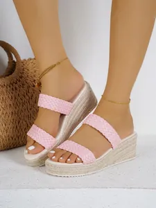 Gedetailleerd overzicht van roze gevlochten sleehak sandalen met espadrille zool