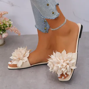 Elegant square toe flat slides featuring a large beige fabric flower decoration for summer.