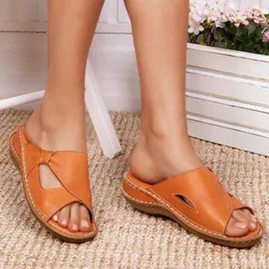 Close-up detail of stylish orange vintage hollow wedge sandals with white contrast stitching