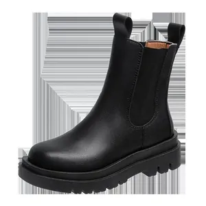 Detailed close-up of black platform Chelsea boots featuring matte finish and pull tabs.