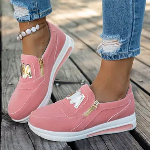 Dettaglio di sneaker in camoscio rosa con cerniera laterale e corona dorata unica