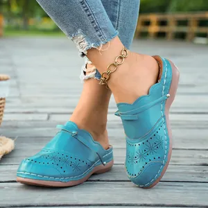 Detalle de los zuecos turquesa para mujer con diseño floral calado y corte por láser