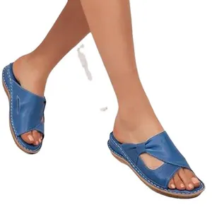 Detailed macro view of blue retro hollowed-out wedge sandals worn on feet for comfort.