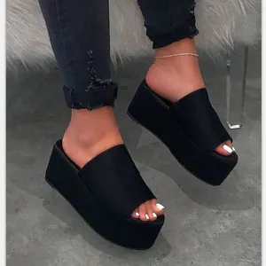 Mujeres elegantes con sandalias de cuña con plataforma negras en una toma detallada