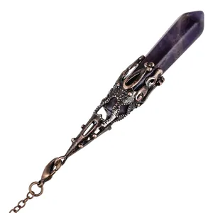 Detail of hexagonal amethyst crystal pendulum pendant with ornate copper filigree.