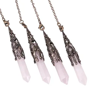 Macro detail of four rose quartz crystal hexagonal column pendants with vintage bronze chains
