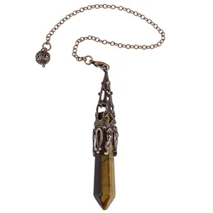 Close-up of Tiger's Eye crystal hexagonal pendulum with ornate bronze filigree work