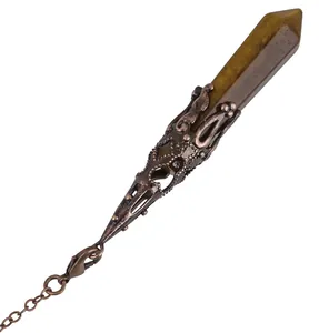 Close-up of hexagonal tiger eye crystal pendulum with antique copper filigree wrap.