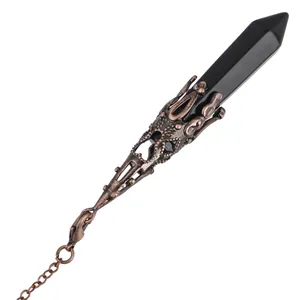 Close-up of hexagonal black crystal pendulum with an ornate antique bronze metal casing detail