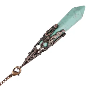 Macro detail showing an ornate bronze filigree casing on a hexagonal turquoise crystal pendulum