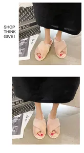 Close-up of comfortable pink fuzzy cross-strap slippers worn by a person indoors