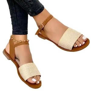 Sandales plates d'été pour femmes avec bride à boucle et bande tissée beige.
