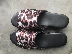 Detalle de sandalias de plataforma para mujer con tiras de satén con estampado de leopardo.