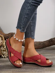 Gros plan de sandales à talons compensés rouges pour femmes avec bracelet de perles