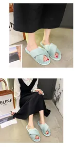 Close-up of light green plush cross-band slippers worn with a black dress and white blouse.