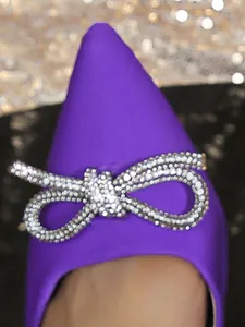Vue détaillée d'un escarpin en satin violet à bout pointu avec un nœud en strass scintillant
