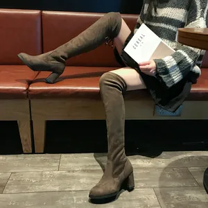 Bottes cuissardes élégantes en daim marron avec talons hauts épais pour un look affiné.