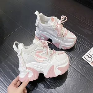 Vista lateral de elegantes zapatillas blancas y rosas de plataforma gruesa con suelas de cuña
