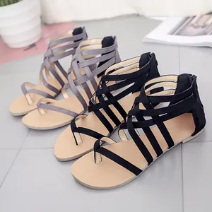 Black and grey strappy flat gladiator sandals with crisscross design and back zipper.