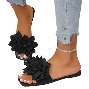 Stylish black flat slippers for women featuring large floral design and open square toe