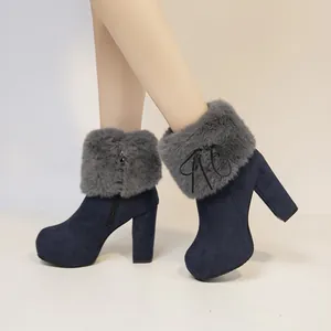 Detail of navy blue suede ankle boots with grey faux fur trim and chunky high heel
