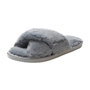 Macro view of plush gray faux fur cross-strap slippers with a flat sole