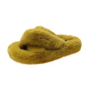Close-up detail of yellow faux fur crossover slide slippers with a plush thick sole.