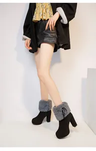 Detail view of black chunky heel winter boots with grey faux fur collar and ribbon bow